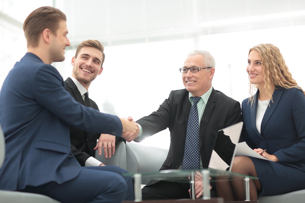 In a sign of cooperation, the partners shake hands after signing